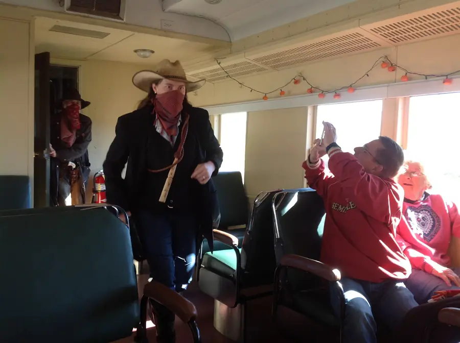 Kristen as a theatrical train robber holding up a festively decorated Heber Valley Railroad car