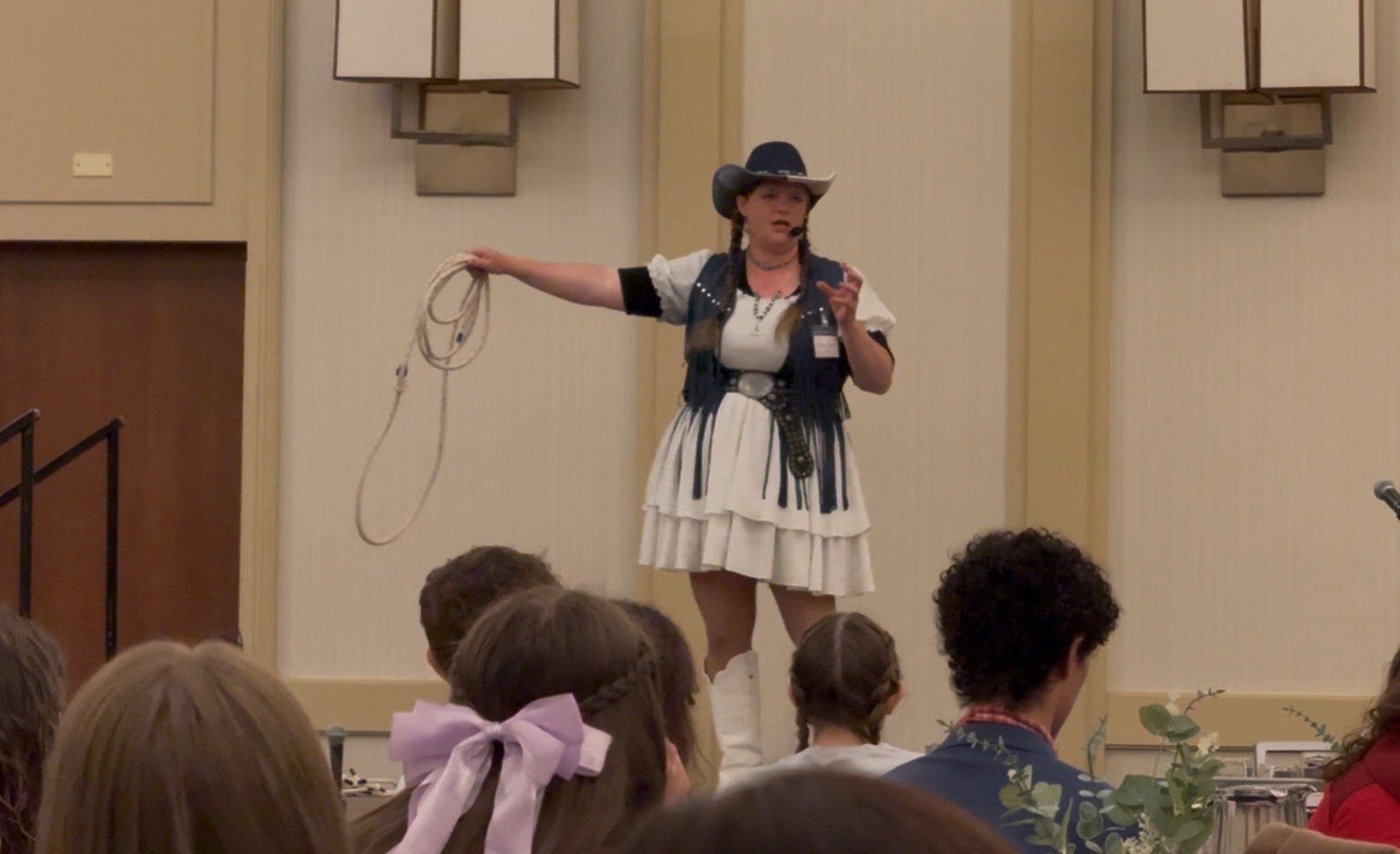 Kristen J. Lloyd delivering her teen keynote with a lasso on stage